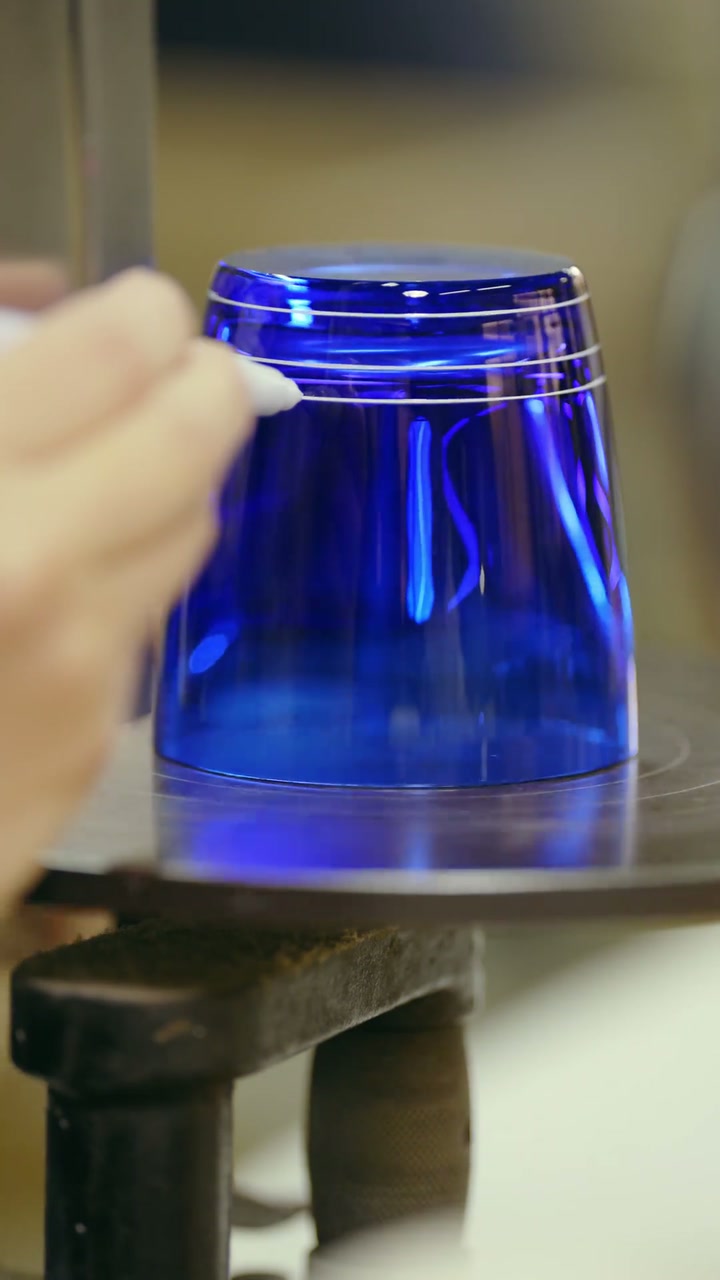 Guide lines being drawn onto a blue glass tumbler